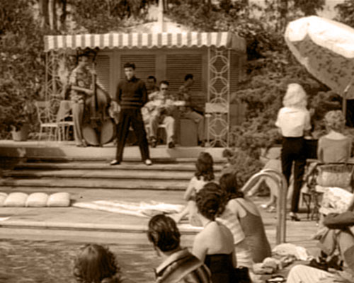 Vince Everett (Elvis Presley) sings "Baby, I Don't Care" at a pool party as a band (Bill Black, DJ Fontana, Scotty Moore, Mike Stoller) plays along in the background in 1957's JAILHOUSE ROCK (MGM)