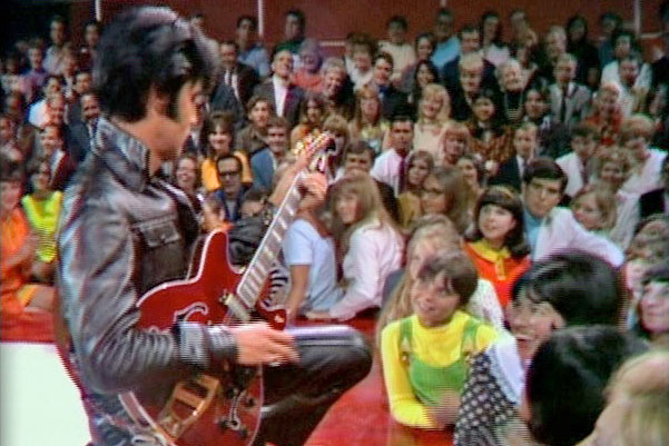 Elvis Presley plays electric guitar for fans during taping of 1968's ELVIS special - NBC